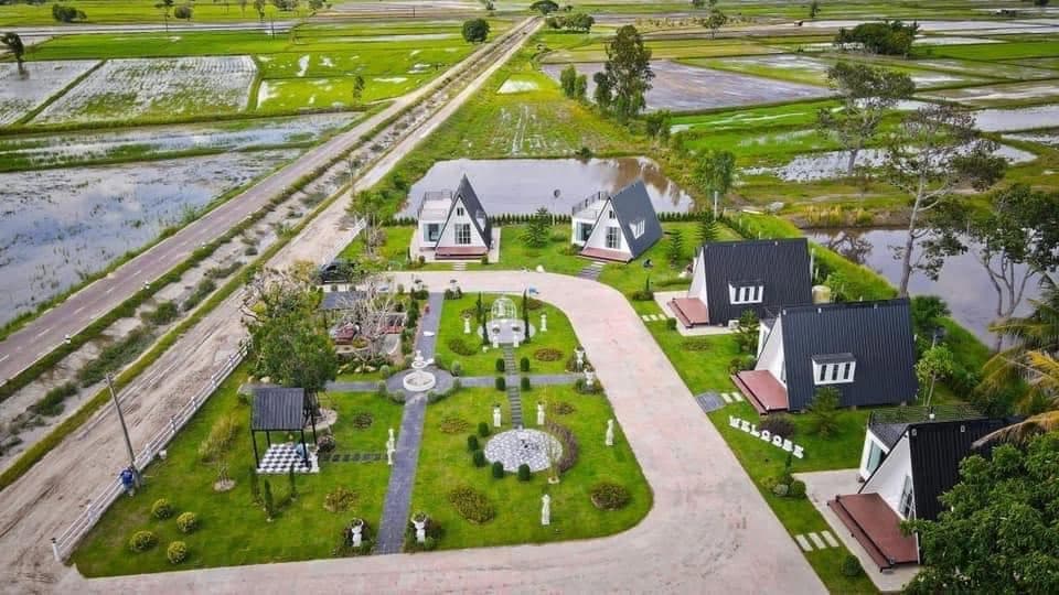 Aerial view of Natcha Villas — A-frame villas among rice fields